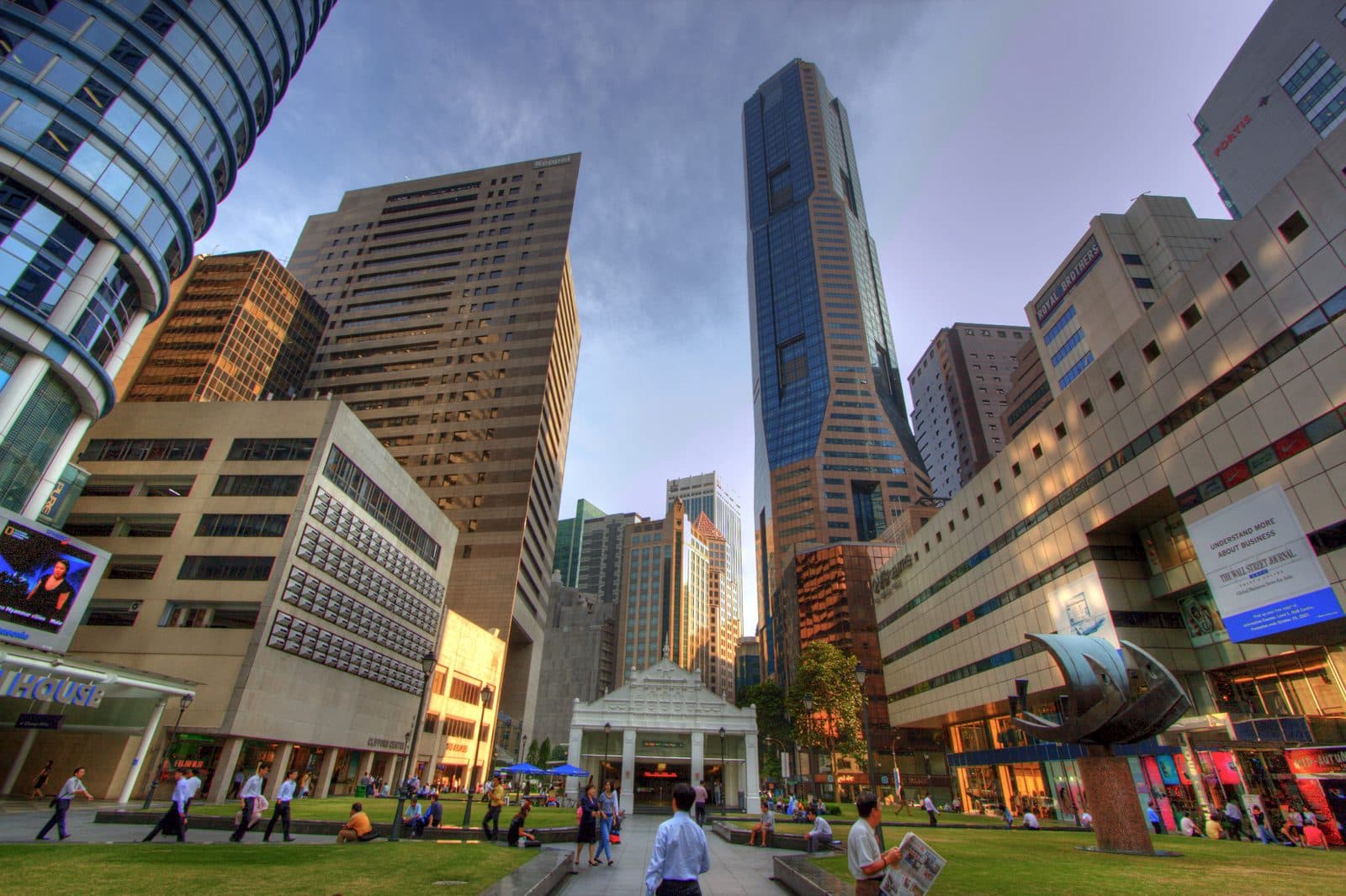 Office towers around Raffles Place in Singapore seen from the square below, with people crossing the open ground